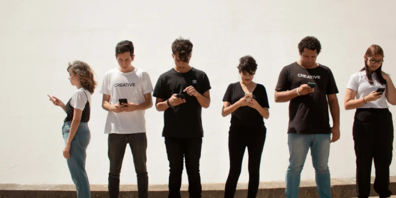 A group of young people looking at their phones